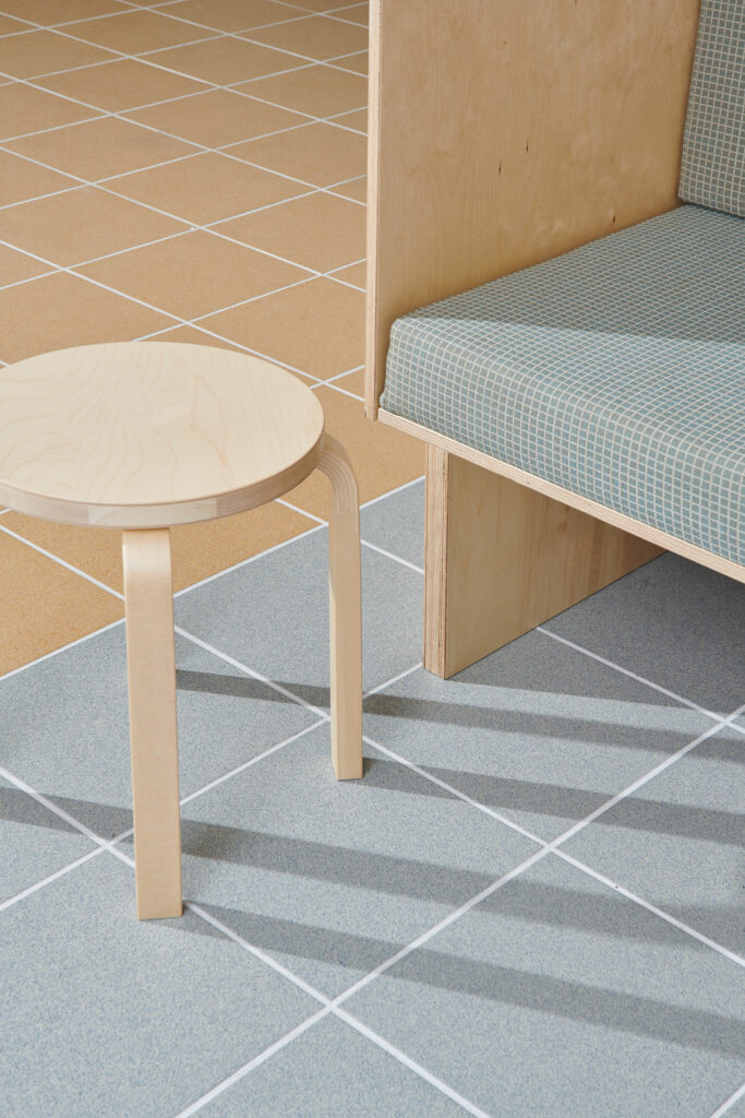 close-up on tiles and seating bench, grey tiles, ash / birch veneer, artek stool