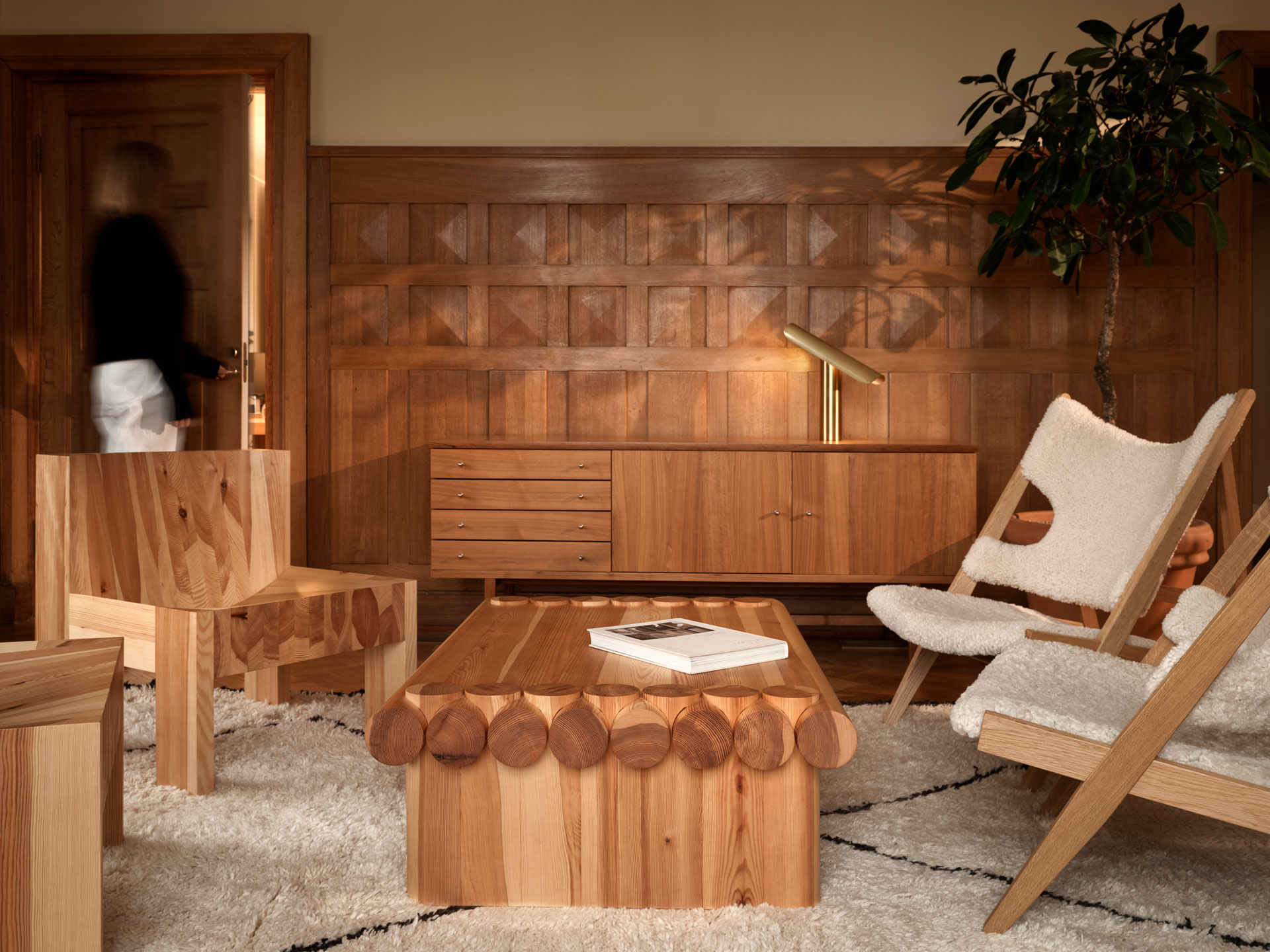 local wooden Finnish furniture from solid wood, two lounge chairs with white upholstery, wooden cabinet storage and wooden panel in the background, warm atmosphere